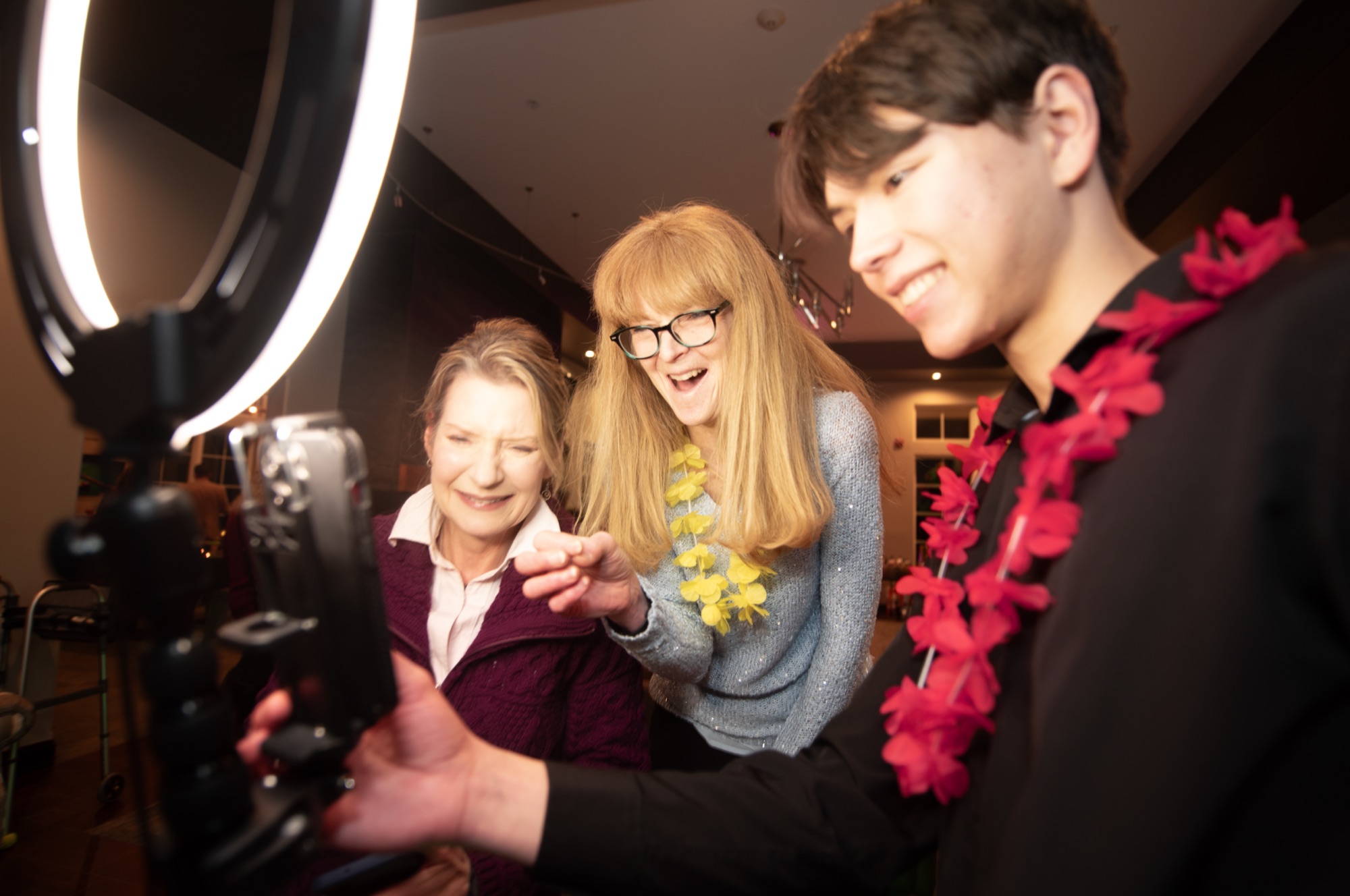 Three guests reviewing their 360 video on the NextSpin 360 booth screen, smiling at the playback.